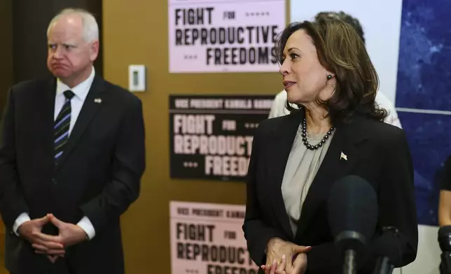 FILE - Minnesota Governor Tim Walz listens to Vice President Kamala Harris speak at Planned Parenthood, March 14, 2024, in St. Paul, Minn. (AP Photo/Adam Bettcher, File)