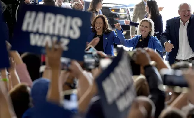 Democratic presidential nominee Vice President Kamala Harris, left, Democratic vice presidential nominee Minnesota Gov. Tim Walz, right, and his wife Gwen Walz arrive at Pittsburgh International Airport, Sunday, Aug. 18, 2024, in Pittsburgh, (AP Photo/Julia Nikhinson)