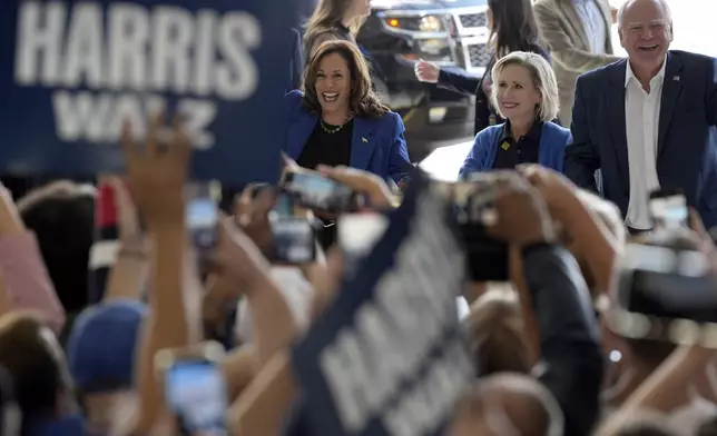 Democratic presidential nominee Vice President Kamala Harris, left, Democratic vice presidential nominee Minnesota Gov. Tim Walz, right, and his wife Gwen Walz arrive at Pittsburgh International Airport, Sunday, Aug. 18, 2024, in Pittsburgh, (AP Photo/Julia Nikhinson)