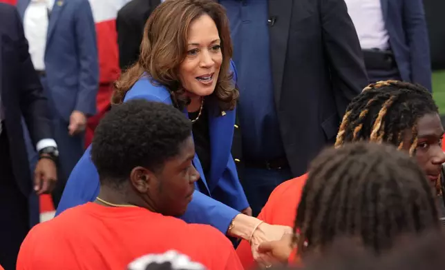 Democratic presidential nominee Vice President Kamala Harris greets members of the Aliquippa High School football team during a campaign stop at their school, Sunday, Aug. 18, 2024, in Aliquippa, Pa. (AP Photo/Julia Nikhinson)