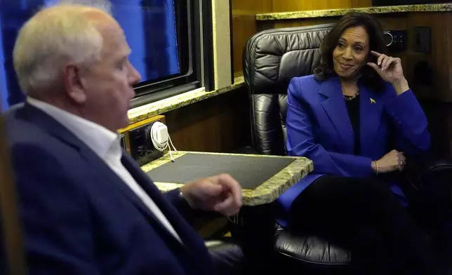 Democratic presidential nominee Vice President Kamala Harris, right, speaks with Democratic vice presidential nominee Minnesota Gov. Tim Walz on a bus during a campaign tour, Sunday, Aug. 18, 2024, in Rochester, Pa. (AP Photo/Julia Nikhinson)