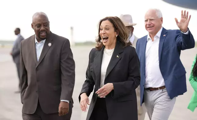 Democratic presidential nominee Vice President Kamala Harris and Democratic vice presidential candidate Minnesota Gov. Tim Walz walk with Savannah Mayor Van Johnson at the Savannah/Hilton Head International Airport in Savannah, Ga., as they arrive for campaign events, Wednesday, Aug. 28, 2024. (AP Photo/Jacquelyn Martin)