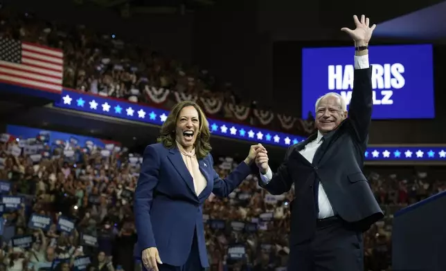 FILE - Democratic presidential nominee Vice President Kamala Harris accompanied, left, by her running mate Minnesota Gov. Tim Walz, appear at a campaign event in Philadelphia, Aug. 6, 2024. (AP Photo/Matt Rourke, File)