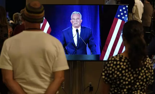 People watch on a monitor as Independent presidential candidate Robert F. Kennedy Jr. announces he is suspending his presidential campaign at a news conference Friday, Aug 23, 2024, in Phoenix. (AP Photo/Darryl Webb)