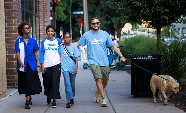 Rep. Ilhan Omar, second from left, walks with her daughters, Isra Hirsi, right, and Ilwad Hirsi, left, and her husband, Tim Mynett, after she talked with media during a campaign stop in Minneapolis, Tuesday, Aug. 13, 2024. (Kerem Yücel/Minnesota Public Radio via AP)