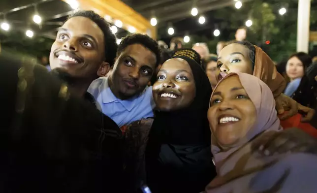 Rep. Ilhan Omar's supporters take a selfie after she won the primary at Nighthawks in Minneapolis, Tuesday, Aug. 13, 2024. (Kerem Yücel/Minnesota Public Radio via AP)