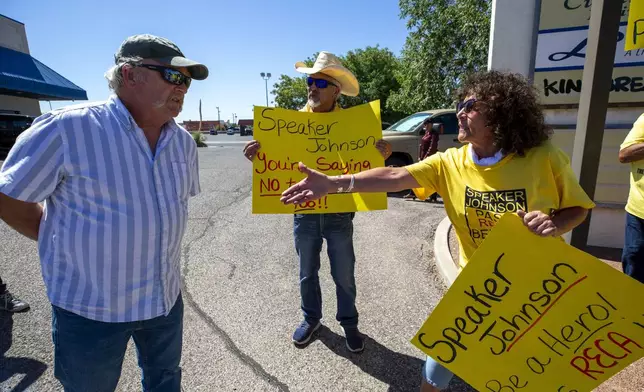 Tina Cordova, right, an activist with the Tularosa Basin Downwinders Consortium, offers a handshake to an attendee of a campaign event with House Speaker Mike Johnson and Republican U.S. House candidate Yvette Herrell of New Mexico, during a demonstration in Las Cruces, N.M., Wednesday, Aug. 21, 2024. The Consortium is asking Speaker Johnson to pass a Senate bill to expand the Radiation Exposure Compensation Act to include New Mexico Downwinders and post 1971 Uranium Miners. (AP Photo/Andres Leighton)