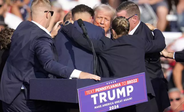 FILE - Republican presidential candidate former President Donald Trump is surrounded by Secret Service at a campaign event in Butler, Pa., July 13, 2024. Few Americans have high confidence in the Secret Service's ability to keep presidential candidates safe after last month's attempt on Trump's life. That is according to a new poll conducted July 25-29, 2024, from the AP-NORC Center for Public Affairs Research. Only around three in 10 Americans are extremely or very confident that the Secret Service can keep the presidential candidates safe from violence before the election. (AP Photo/Gene J. Puskar, File)