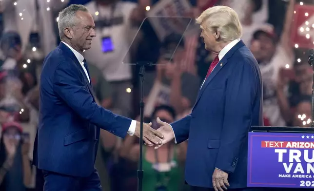 Independent presidential candidate Robert F. Kennedy Jr., left, shakes hands with Republican presidential nominee former President Donald Trump at a campaign rally Friday, Aug. 23, 2024, in Glendale, Ariz. (AP Photo/Ross D. Franklin)