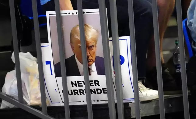 A supporter holds a sign in the bleachers for Republican presidential candidate former President Donald Trump at a campaign rally at Georgia State University in Atlanta, Saturday, Aug. 3, 2024. (AP Photo/Ben Gray)