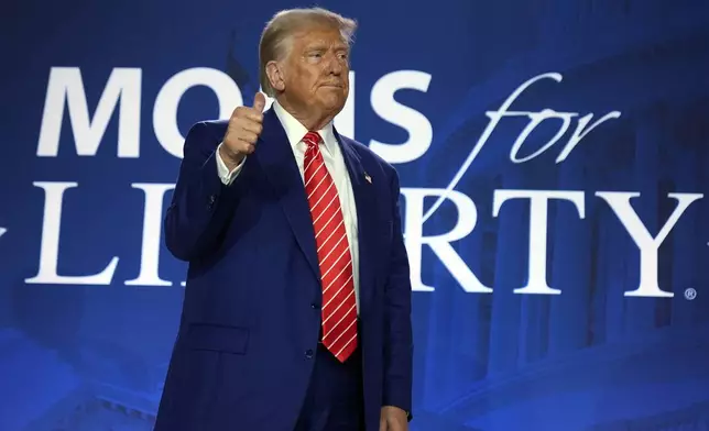 Republican presidential nominee former President Donald Trump gestures after speaking with Moms for Liberty co-founder Tiffany Justice during an event at the group's annual convention in Washington, Friday, Aug. 30, 2024. (AP Photo/Mark Schiefelbein)