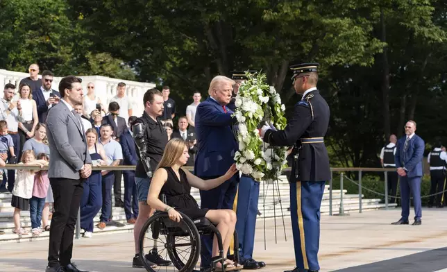 Marlon Bateman, left, former Marine Sgt. Tyler Vargas, second from left, former Marine Cpl. Kelsee Lainhart, center, and Republican presidential nominee former President Donald Trump place a wreath at the Tomb of the Unknown Solider in honor of the 13 service members killed at Abbey Gate, at Arlington National Cemetery, Monday, Aug. 26, 2024, in Arlington, Va. (AP Photo/Alex Brandon)