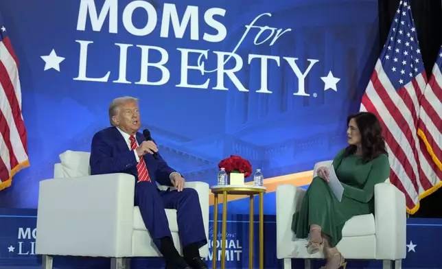 Republican presidential nominee former President Donald Trump speaks with Moms for Liberty co-founder Tiffany Justice during an event at the group's annual convention in Washington, Friday, Aug. 30, 2024. (AP Photo/Mark Schiefelbein)