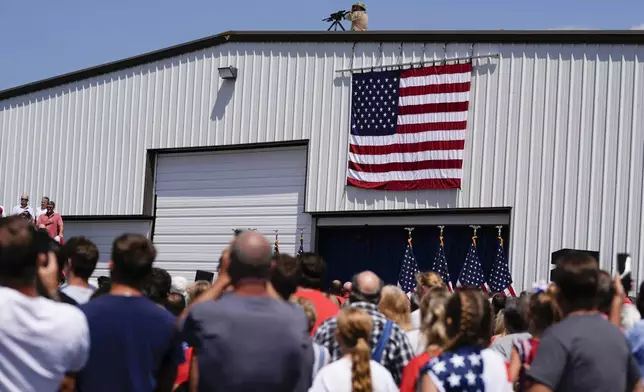 Rooftop security is in position prior to Republican presidential nominee former President Donald Trump speaks at a rally, Wednesday, Aug. 21, 2024, in Asheboro, N.C. Wednesday's event is the first outdoor rally Trump has held since the attempted assassination of the former president. (AP Photo/Julia Nikhinson)