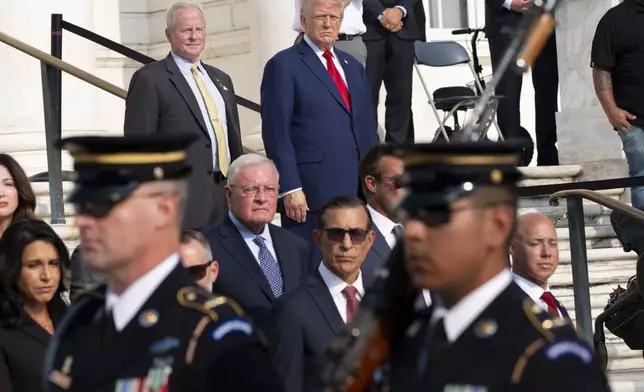 Bob Quackenbush, top left, deputy chief of staff for Arlington National Cemetery, and Republican presidential nominee former President Donald Trump watch the changing of the guard at the Tomb of the Unknown Solider at Arlington National Cemetery, Monday, Aug. 26, 2024, in Arlington, Va. (AP Photo/Alex Brandon)