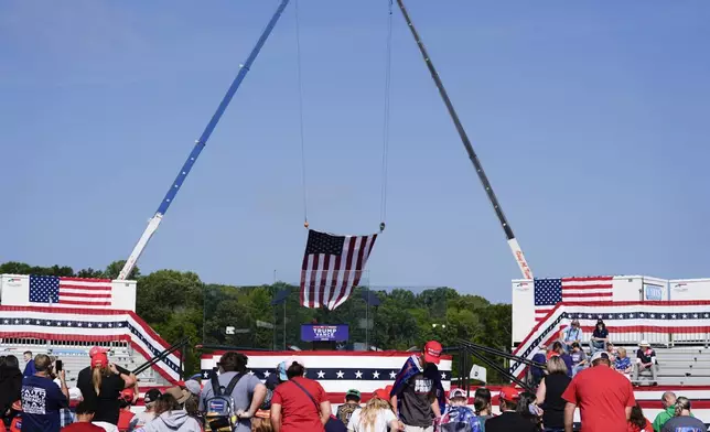 An outdoor stage is set encased with bulletproof glass as supporters arrive to hear Republican presidential nominee former President Donald Trump speak at a rally, Wednesday, Aug. 21, 2024, in Asheboro, N.C. Trump is holding his first outdoor rally since narrowly surviving an attempted assassination when a a gunman opened fire in Pennsylvania last month. (AP Photo/Julia Nikhinson)