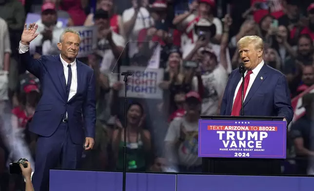 Independent presidential candidate Robert F. Kennedy Jr., left, waves to the crowd as Republican presidential nominee former President Donald Trump speaks at a campaign rally Friday, Aug. 23, 2024, in Glendale, Ariz. (AP Photo/Ross D. Franklin)