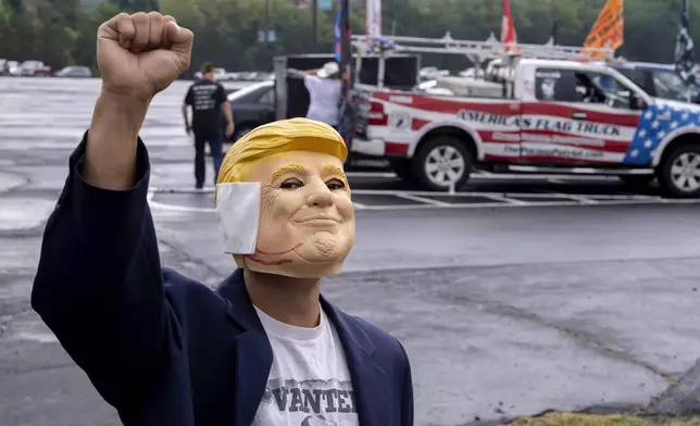 "Breakdancer for Trump" Victor Moon poses in a Donald Trump mask before campaign rally for Republican presidential nominee former President Trump at the Mohegan Sun Arena at Casey Plaza in Wilkes-Barre, Pa., Saturday, Aug. 17, 2024. (AP Photo/Laurence Kesterson)