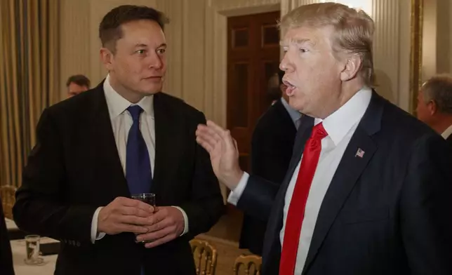 FILE - President Donald Trump, right, talks with Tesla and SpaceX CEO Elon Musk at the White House in Washington, Feb. 3, 2017. (AP Photo/Evan Vucci, File)