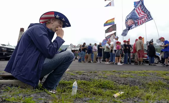 Timothy Denhollander, of New Jersey, finishes a hot dog before a rally for Republican presidential nominee former President Donald Trump at the Mohegan Sun Arena at Casey Plaza, Saturday, Aug. 17, 2024, in Wilkes-Barre, Pa. (AP Photo/Carolyn Kaster)