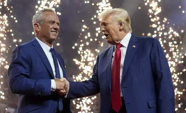 Republican presidential nominee former President Donald Trump shakes hands with Independent presidential candidate Robert F. Kennedy Jr. at a campaign rally at the Desert Diamond Arena, Friday, Aug. 23, 2024, in Glendale, Ariz. (AP Photo/Evan Vucci)