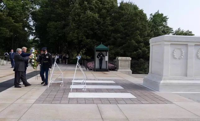 Bill Barnett, left, grandfather of Darin Taylor Hoover, and Republican presidential nominee former President Donald Trump place a wreath at the Tomb of the Unknown Solider in honor of Staff Sgt. Darin Taylor Hoover at Arlington National Cemetery, Monday, Aug. 26, 2024, in Arlington, Va. (AP Photo/Alex Brandon)