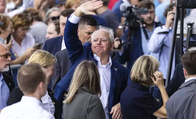 Democratic vice presidential nominee Minnesota Gov. Tim Walz waves to the crowd outside after a campaign rally, Saturday, Aug. 17, 2024, at The Astro in La Vista, Neb. (AP Photo/Bonnie Ryan)