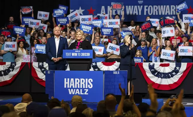 Democratic vice presidential nominee Minnesota Gov. Tim Walz, left, is introduced by his former student Aubri Faustman at a campaign rally, Saturday, Aug. 17, 2024, at The Astro in La Vista, Neb. (AP Photo/Bonnie Ryan)