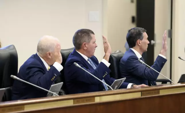 Santee Cooper CEO Jimmy Staton, left, Dominion Energy South Carolina President Keller Kissam, center, and Duke Energy's utility operations in South Carolina President Mike Callahan, right, are sworn in before testifying before a South Carolina Senate committee planning to write a comprehensive energy bill in 2025. in Columbia, S.C., on Thursday, Aug. 22 2024. (AP Photo/Jeffrey Collins)