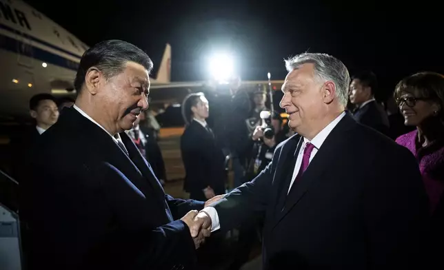 FILE -In this image provided by the Hungarian Prime Minister's Office, Chinese President Xi Jinping, left, shakes hands with Hungarian Prime Minister Viktor Orban as he arrives for a state visit at the Liszt Ferenc International Airport in Budapest, Hungary, Wednesday, May 8, 2024. (Vivien Cher Benko/Hungarian Prime Minister's Office/MTI via AP, File)