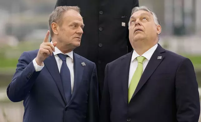 FILE - Hungary's Prime Minister Viktor Orban, right, speaks with Poland's Prime Minister Donald Tusk as they pose for a group photo during an Nuclear Energy Summit at the Expo in Brussels, on March 21, 2024. (AP Photo/Virginia Mayo, File)