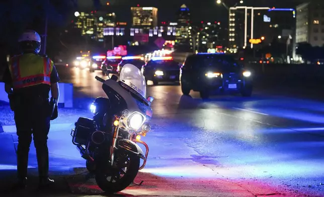 A procession of Dallas police vehicles exits the Stemmons Fwy near the medical examiner's office in the early morning hours of Friday, Aug. 30, 2024, in Dallas. (Smiley N. Pool/The Dallas Morning News via AP)