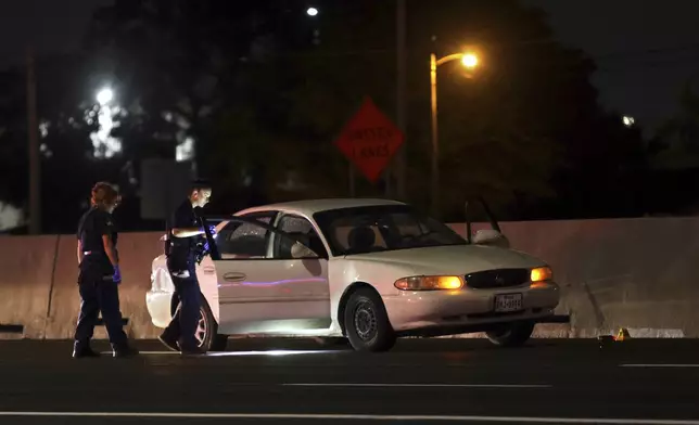 Officers examine a vehicle for evidence in Lewisville, Texas, on Friday Aug 30, 2024. (Jason Janik/The Dallas Morning News via AP)