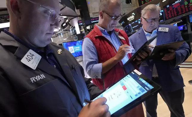 A trio of traders work on the floor of the New York Stock Exchange, Friday, Aug. 2, 2024. (AP Photo/Richard Drew)