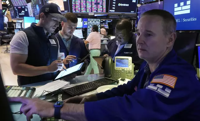 Traders gather at the post of specialist Stephen Naughton, right,on the floor of the New York Stock Exchange, Friday, Aug. 2, 2024. (AP Photo/Richard Drew)