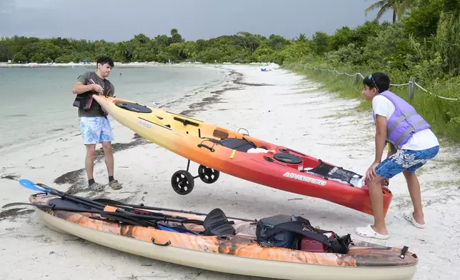 Joshua Gross, right, and his brother Joseph, of Miami, prepare to launch their kayaks off the beach at Oleta River State Park, Thursday, Aug. 22, 2024, in North Miami Beach, Fla. (AP Photo/Marta Lavandier)