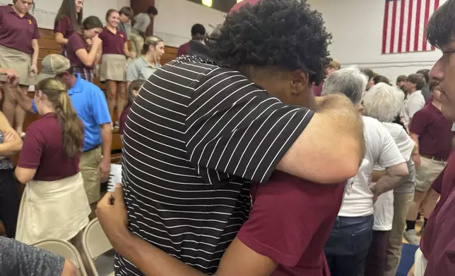 Jamie Tellier, father of Caden Tellier, hugs a student after a memorial service for Tellier's son in Selma, Ala., Monday, Aug. 26, 2024. (AP Photo/Safiyah Riddle)