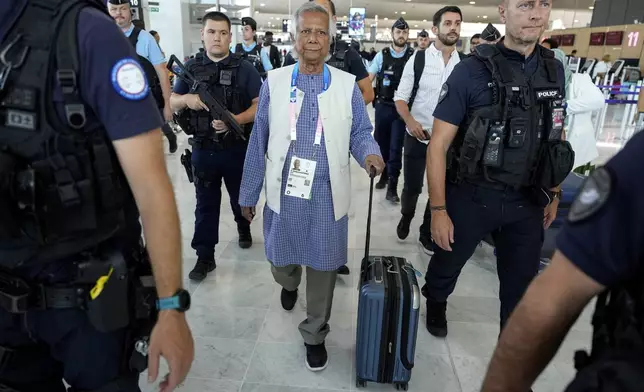 Nobel laureate Muhammad Yunus walks with his luggage at Charles de Gaulle's airport in Roissy, north of Paris, Wednesday, Aug. 7, 2024. (AP Photo/Michel Euler)