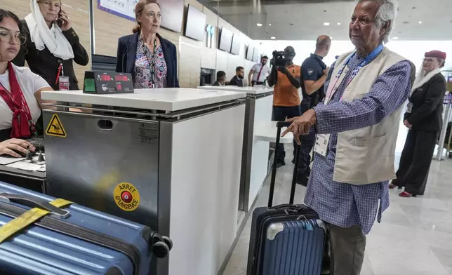 Nobel laureate Muhammad Yunus checks in his luggage at Charles de Gaulle's airport in Roissy, north of Paris, Wednesday, Aug. 7, 2024. (AP Photo/Michel Euler)