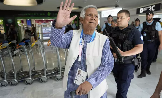 Nobel laureate Muhammad Yunus waves to the media at Charles de Gaulle's airport in Roissy, north of Paris, Wednesday, Aug. 7, 2024. (AP Photo/Michel Euler)