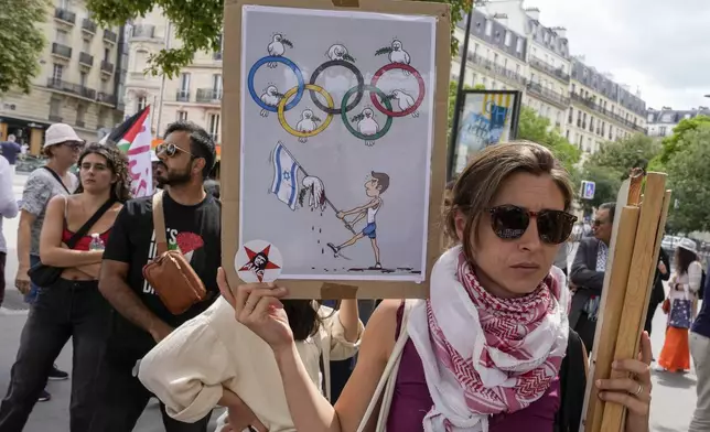 A protester holds a placard during a gathering in support of Palestinian people in Gaza, in Paris, Saturday Aug. 3, 2024. (AP Photo/Michel Euler)