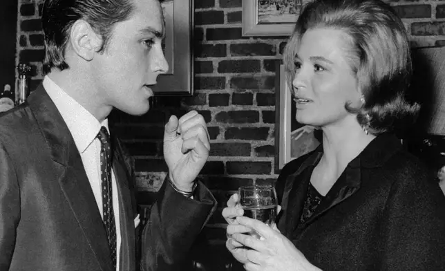 FILE - French actor Alain Delon of France gets the attention of actress Angie Dickinson during a conversation at a cocktail party in Beverly Hills, Calif.on April 16, 1963. Alain Delon, the internationally acclaimed French actor who embodied both the bad guy and the policeman and made hearts throb around the world, has died at age 88, French media reported(AP Photo/Harold Matosian, File)