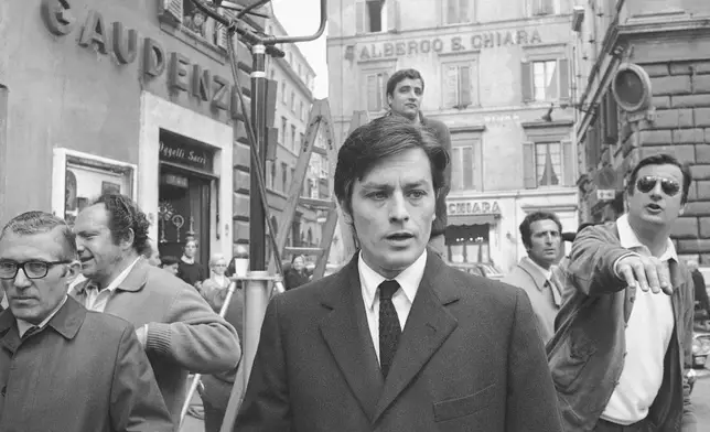 FILE - French actor Alain Delon takes a short walk away from the set of a new film, "The Sicilians," during a break in the shooting in the center of Rome, on March 27, 1969. Alain Delon, the internationally acclaimed French actor who embodied both the bad guy and the policeman and made hearts throb around the world, has died at age 88, French media reported. (AP Photo/Jim Pringle, File)