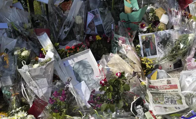 Photographs and flowers left by fans in tribute to late French actor Alain Delon are on display at the entrance gate of Delon's property, in Douchy, central France, Saturday, Aug. 24, 2024. (AP Photo/Thibault Camus)