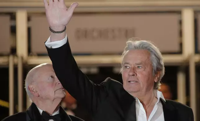 Actor Alain Delon, right, waves as festival director Gilles Jacob looks on as Delon arrives for the screening of Plein Soleil at the 66th international film festival, in Cannes, southern France, Saturday, May 25, 2013. Alain Delon, the internationally acclaimed French actor who embodied both the bad guy and the policeman and made hearts throb around the world, has died at age 88, French media reported. (AP Photo/Lionel Cironneau)