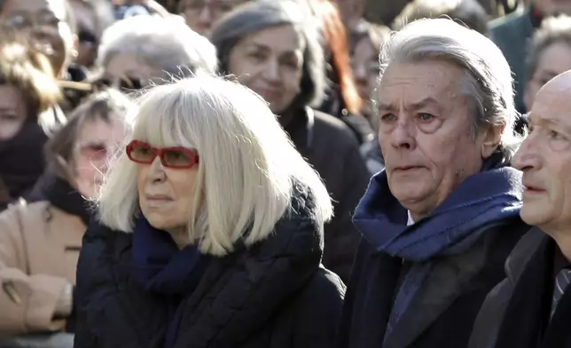 FILE - French actor Alain Delon, right, and French actress Mireille Darc arrive at the funeral ceremony of French actress Annie Girardot held at the Saint Roch church in Paris on March 4, 2011. Alain Delon, the internationally acclaimed French actor who embodied both the bad guy and the policeman and made hearts throb around the world, has died at age 88, French media reported. (AP Photo/Thibault Camus, File)