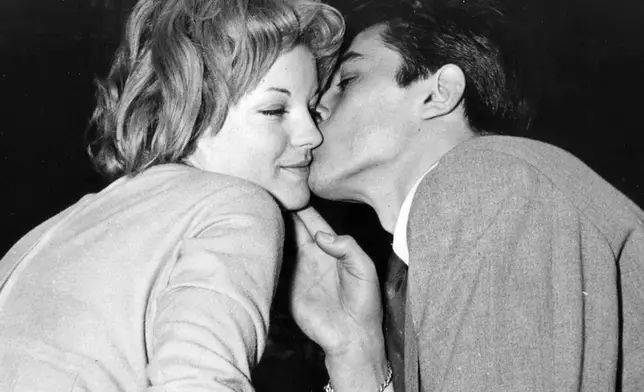 FILE - Romy Schneider is kissed by French actor Alain Delon in Morcote near Lugano, Switzerland, after their engagement on March 22, 1959. Alain Delon, the internationally acclaimed French actor who embodied both the bad guy and the policeman and made hearts throb around the world, has died at age 88, French media reported. (AP Photo, File)