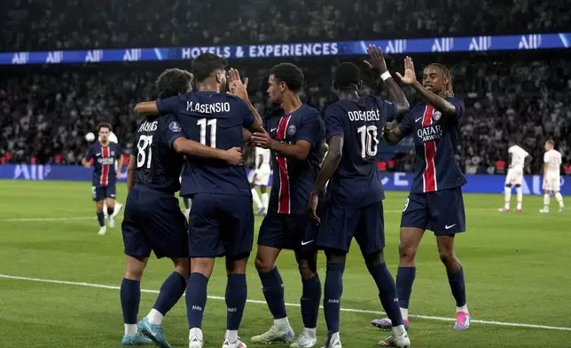 PSG's Marco Asensio, back to camera, celebrates with teammates after scoring his side's second goal during the French League 1 soccer match between Paris Saint-Germain and Montpellier at the Parc des Princes in Paris, Friday, Aug. 23, 2024. (AP Photo/Thibault Camus)