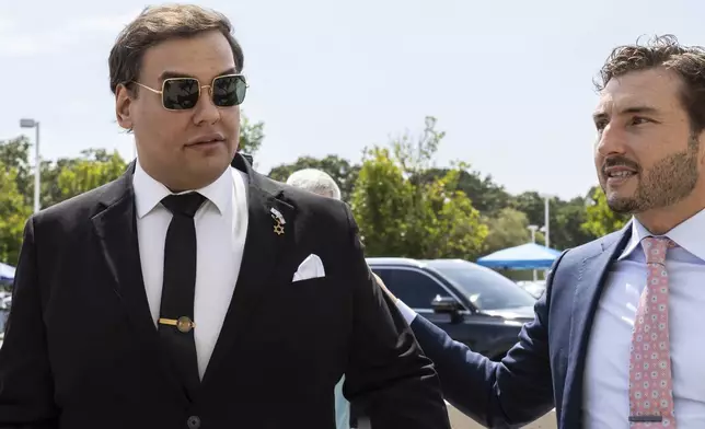 Former U.S. Rep. George Santos, left, arrives at court with his lawyer, Andrew Mancilla, in Central Islip, N.Y., Monday, Aug. 19, 2024. (AP Photo/Stefan Jeremiah)