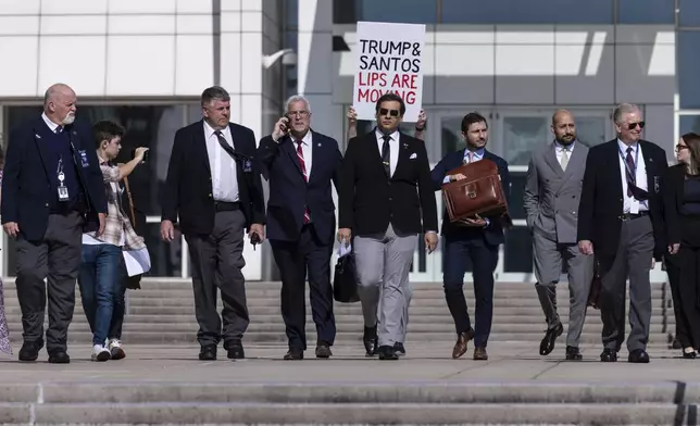 Former U.S. Rep George Santos leaves the federal courthouse with his lawyers in Central Islip, N.Y. on, Monday, Aug., 19, 2024. (AP Photo/Stefan Jeremiah)